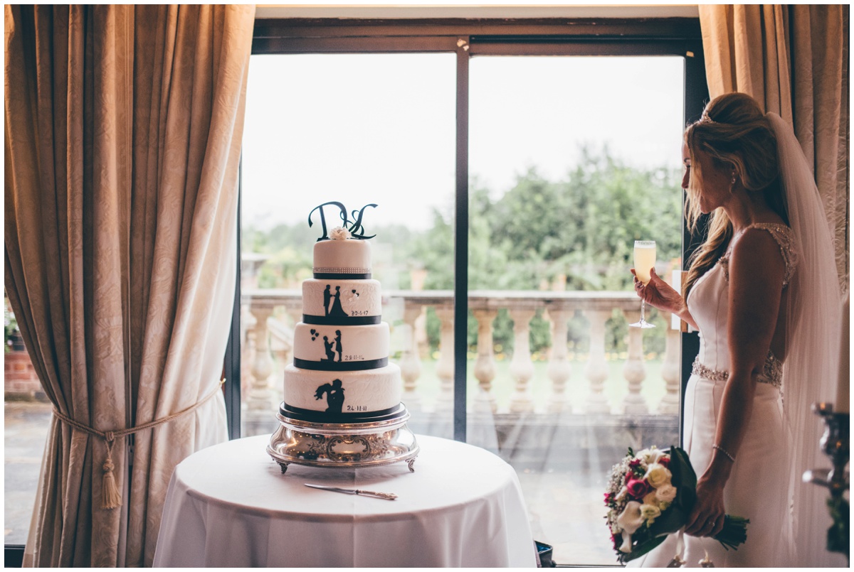 The beautiful bride admires her silhouette themed wedding cake.