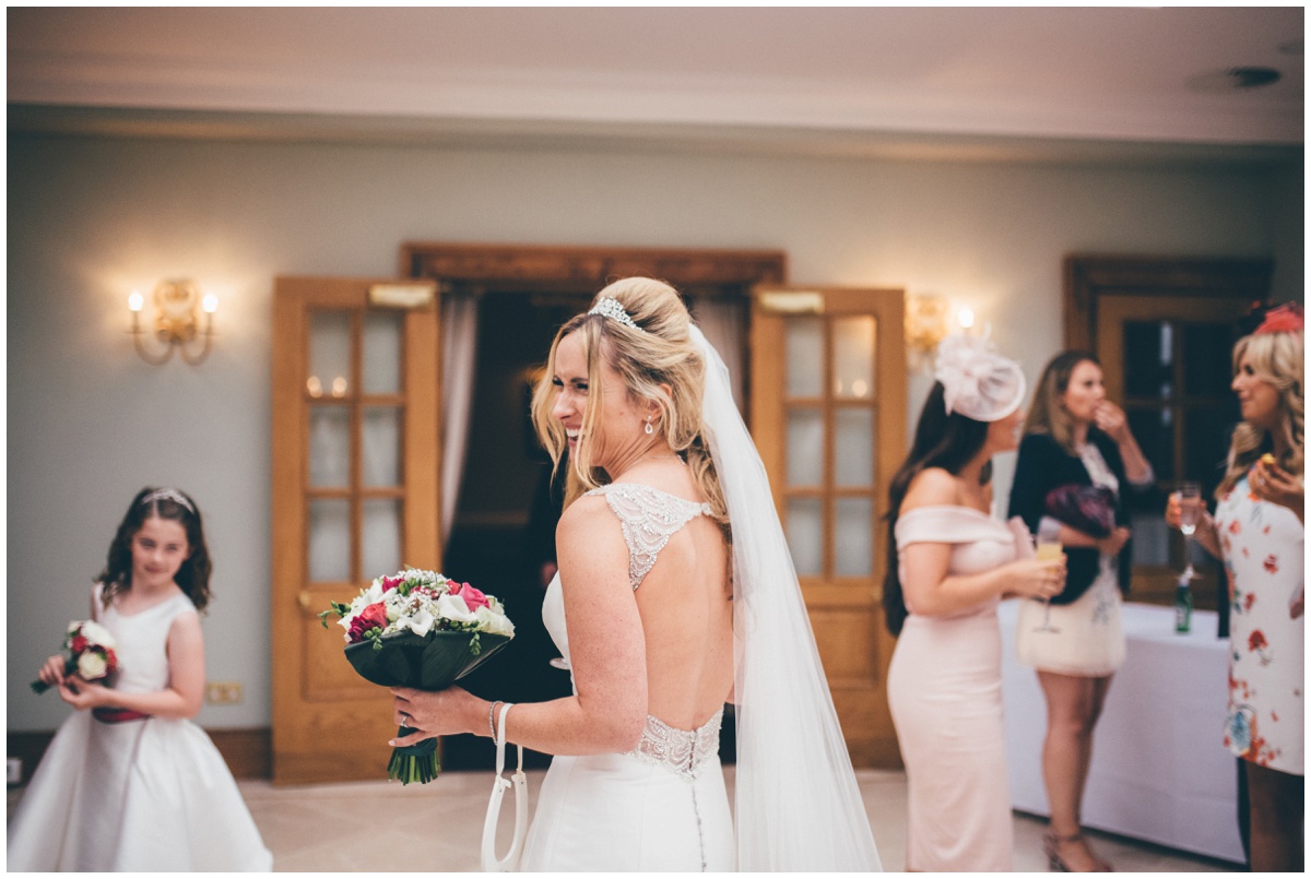 The beautiful bride greets her wedding guests at her reception at Willington Hall in Cheshire.