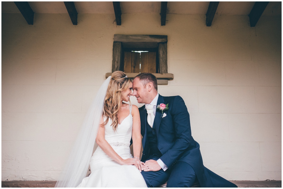 Bride and groom sit face to face in the summerhouse at Willington Hall in Tarporley.