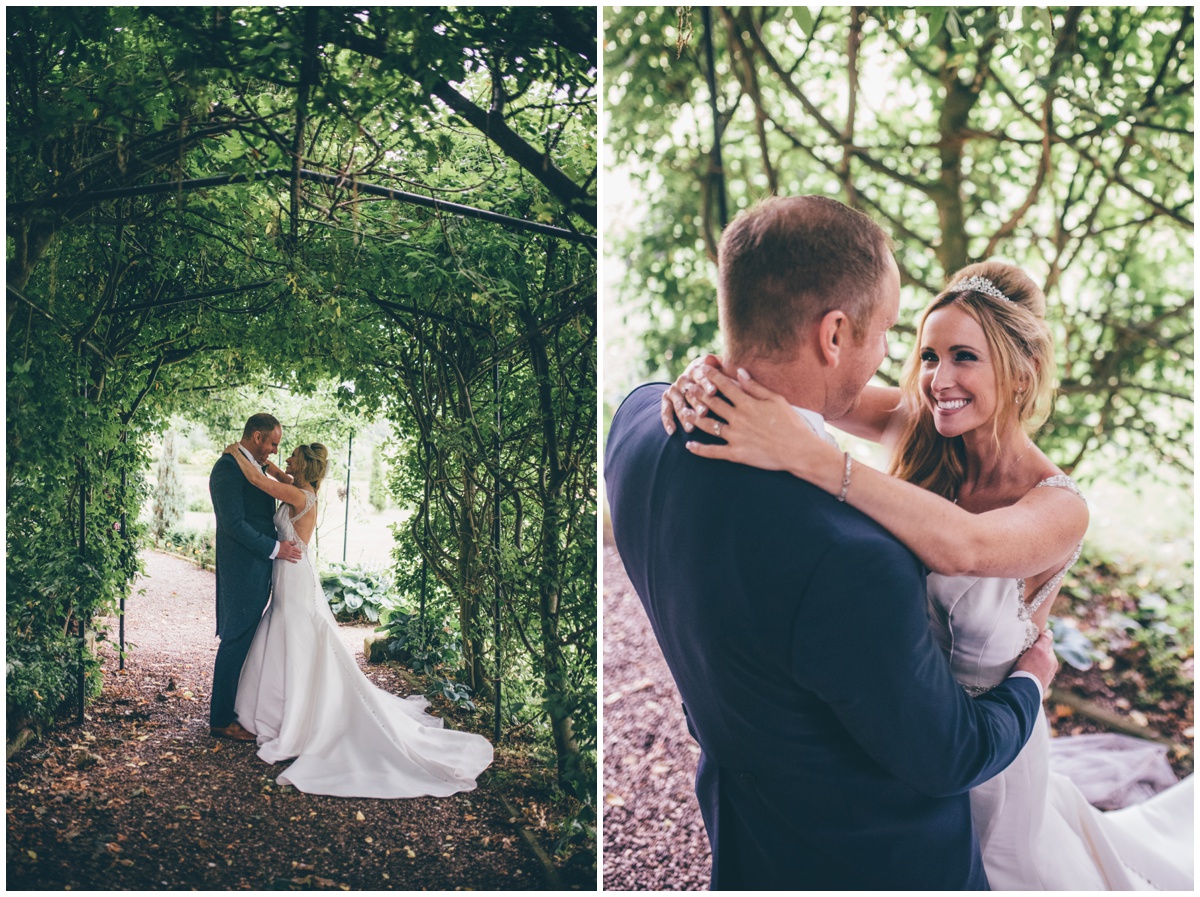The happy couple embrace amidst the greenery in the beautiful gardens at Willington Hall in Cheshire.