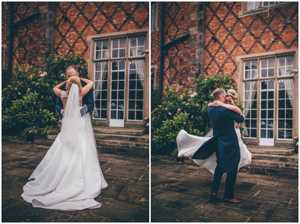 Groom swinging his laughing bride around, her gorgeous long train floats in the wind.