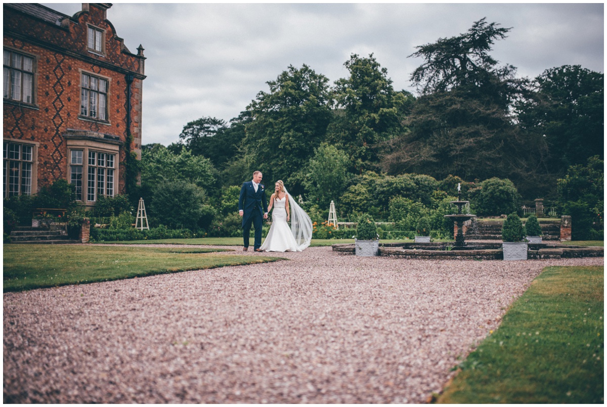 The newlyweds walk hand in hand through the grounds of their beautiful wedding venue in Tarporley, Cheshire.