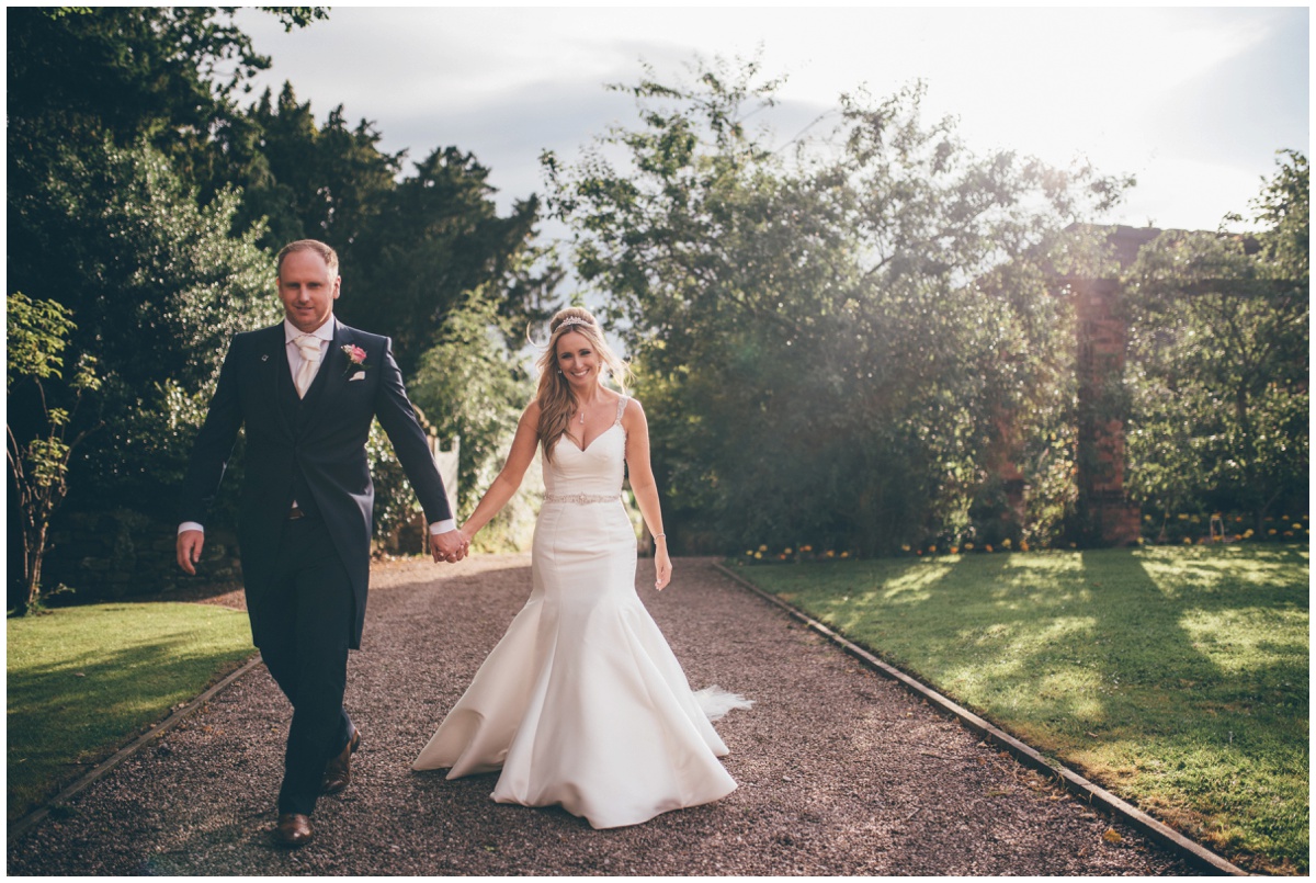 Couple have their portraits in the gardens at Willington Hall during their summertime wedding..