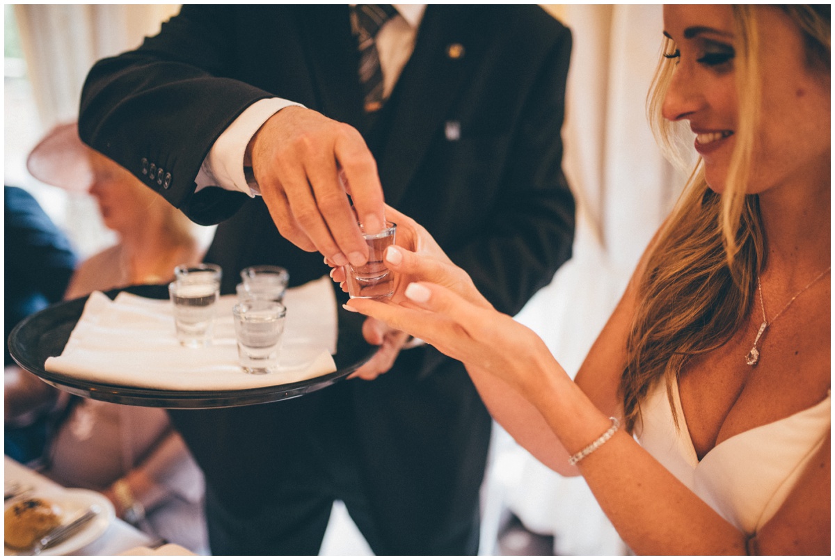 Bride takes a shot of Sambuca in her evening reception at her wedding.