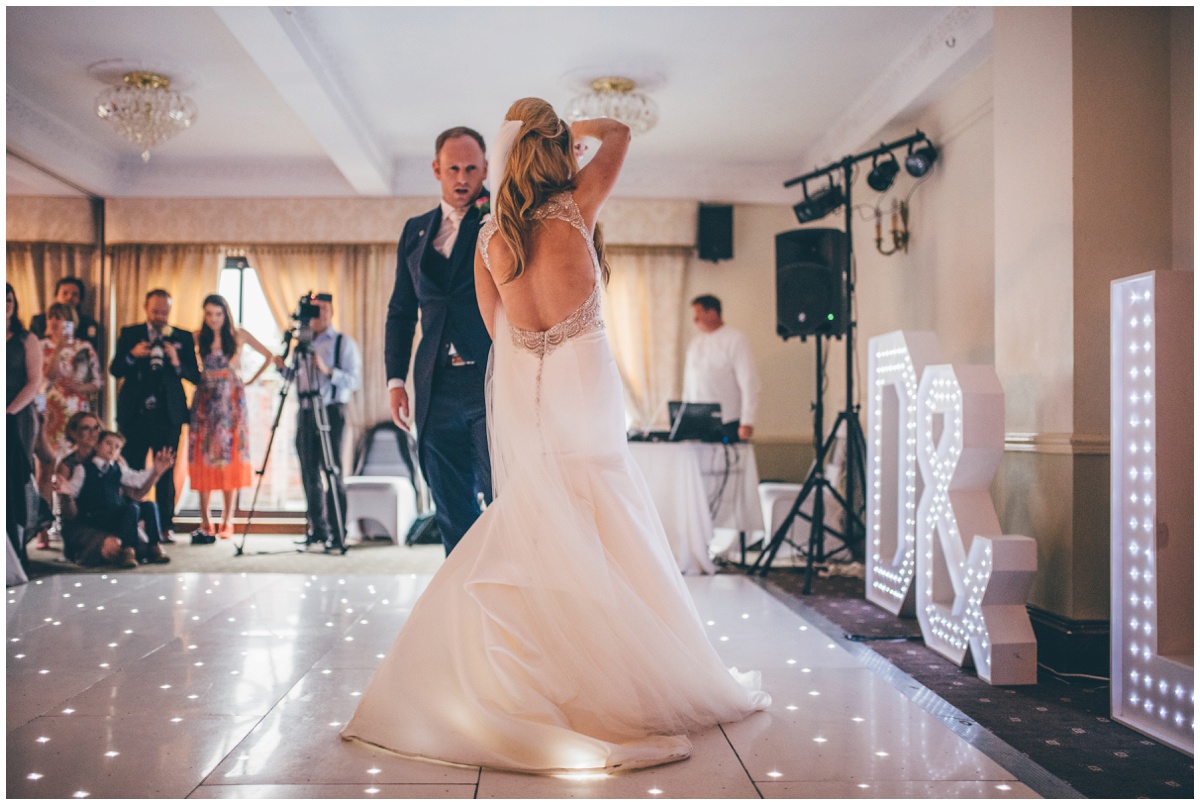 The groom twirls his new wife around on the dancefloor during their First Dance.