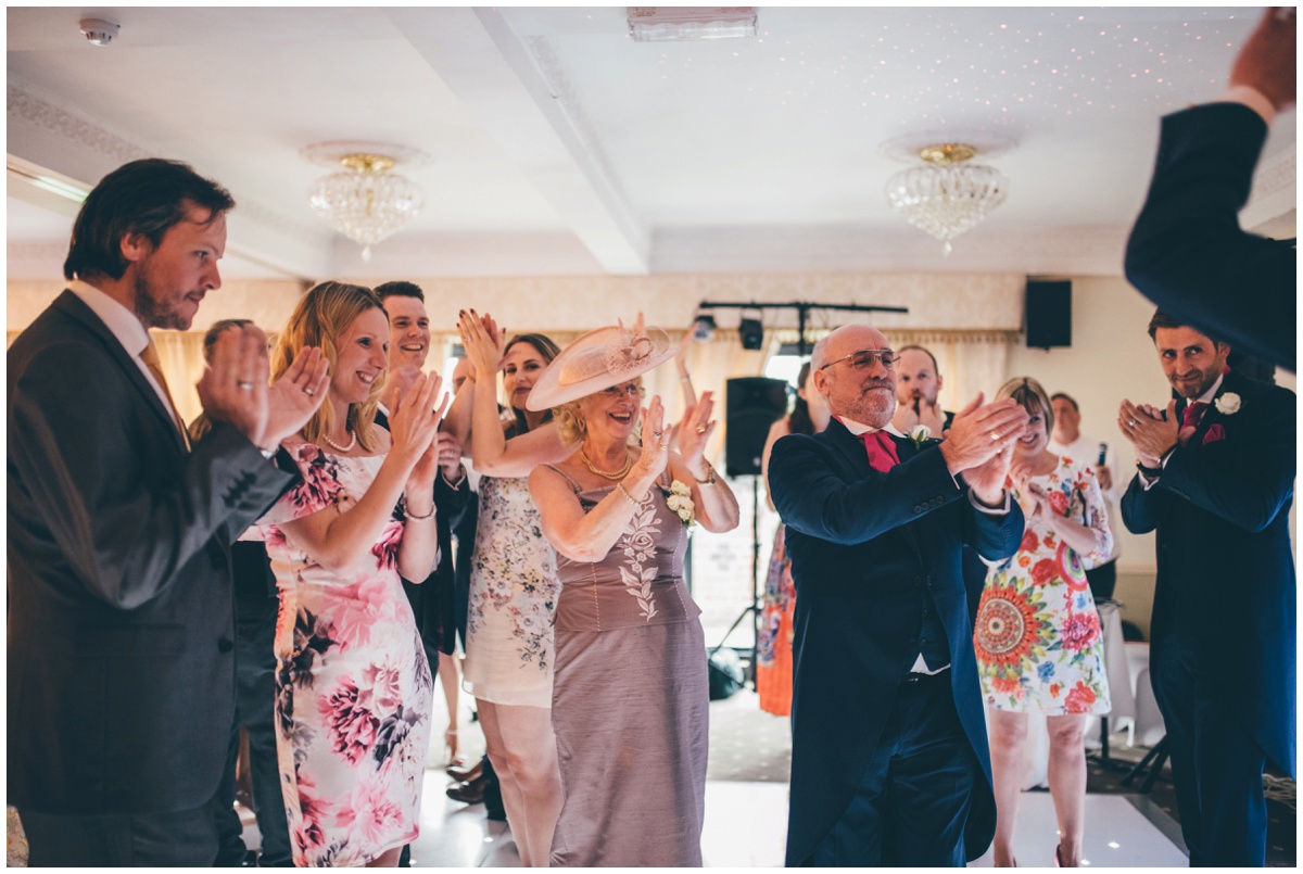 The wedding guests all cheer the bride and groom during their First Dance at Willington Hall in Cheshire.