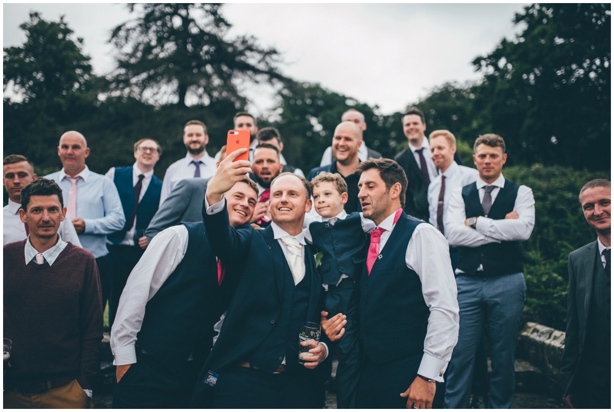 The groom takes a selfie with all the guys at his wedding in the beautiful gardens at Willington Hall.