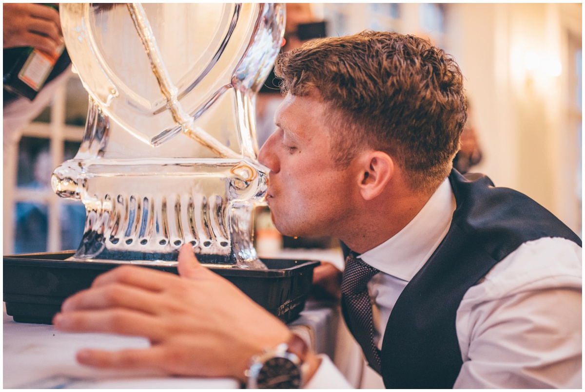 A wedding guest tries the jagermeister with the luge at the fun wedding reception at Willington Hall.