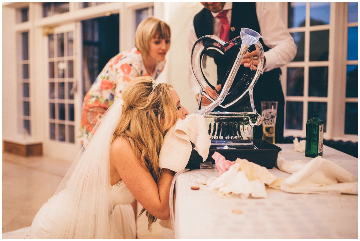 The bride has a go on the jagermeister luge at their wedding reception at Willington Hall.