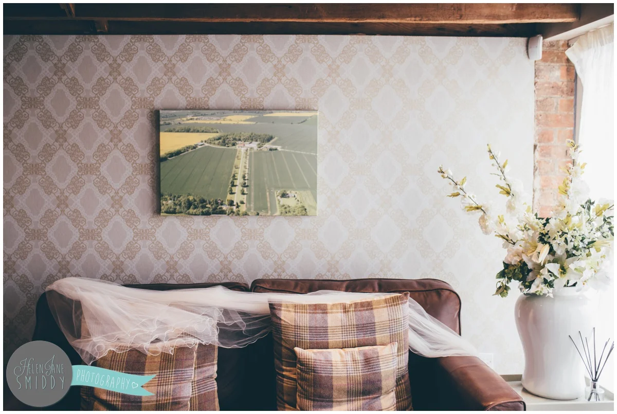 Bride's veil laid across the sofa in the bridal suite at Bassmean Manor Barns.