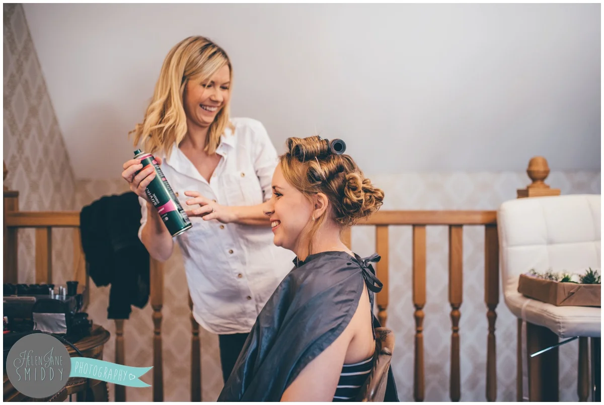 The bride gets her hair done in the bridal suite on the morning of her wedding at Bassmead Manor.