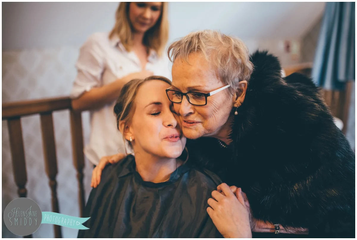 The bride's grandma gives her a good luck kiss on the morning of her wedding.