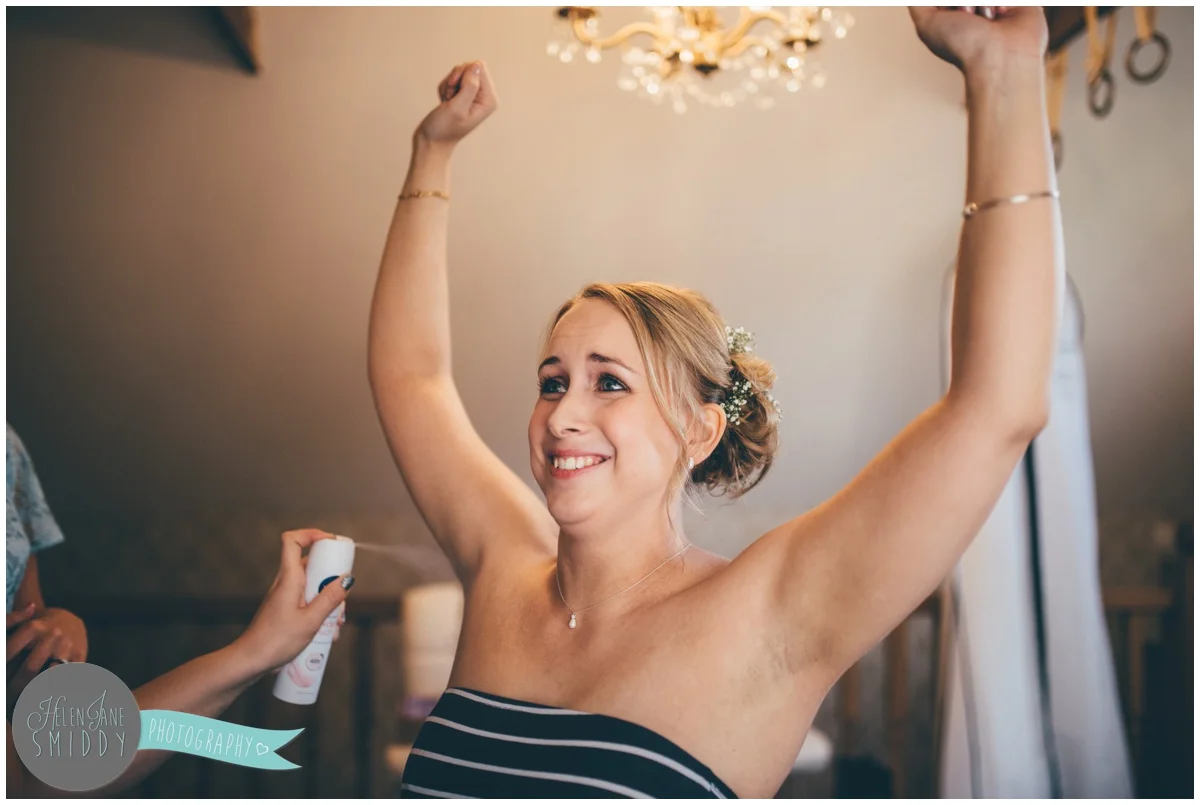 Funny bride has deodorant sprayed on her wedding morning.