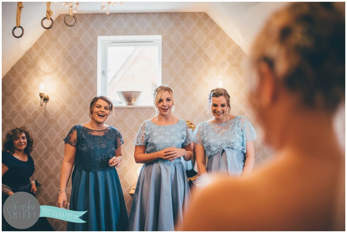 Beautiful bridesmaids see the bride for the first time in her wedding gown at Bassmead Manor.