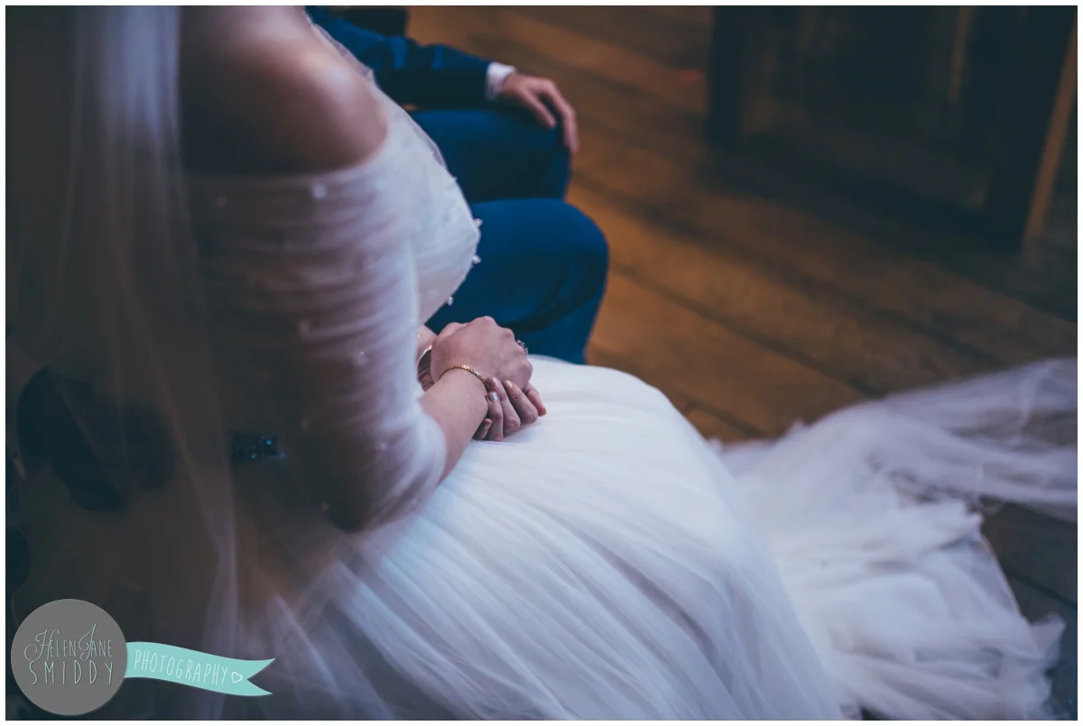 The couple hold hands during their wedding ceremony.