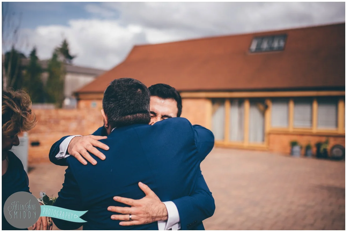 Groom hugs his Dad and celebrates his new marriage.