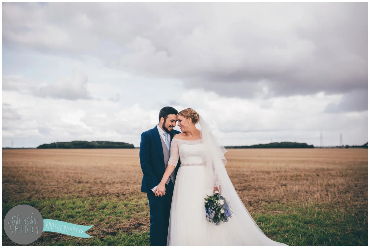 The couple share an intimate moment during their wedding photgraphs which were in a field at Bassmead Manor wedding barns.