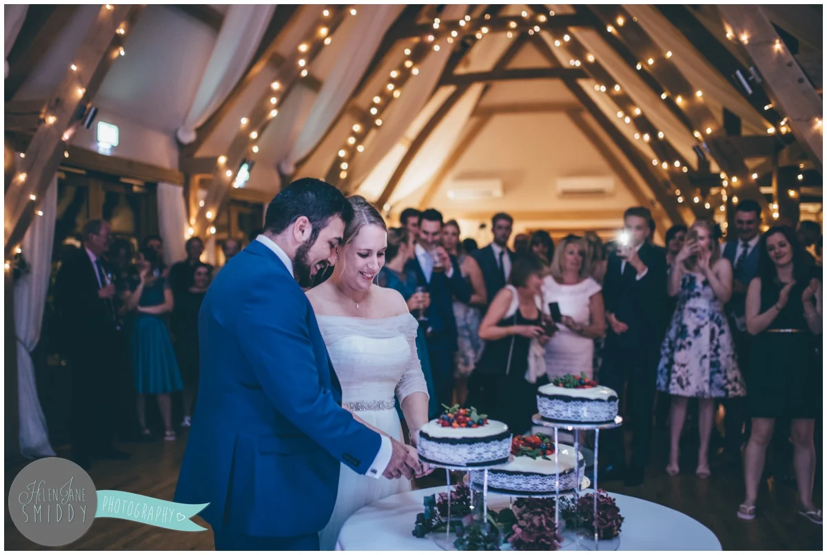 Bride and groom cut their homemade wedding cake at Bassmead Manor wedding barns.