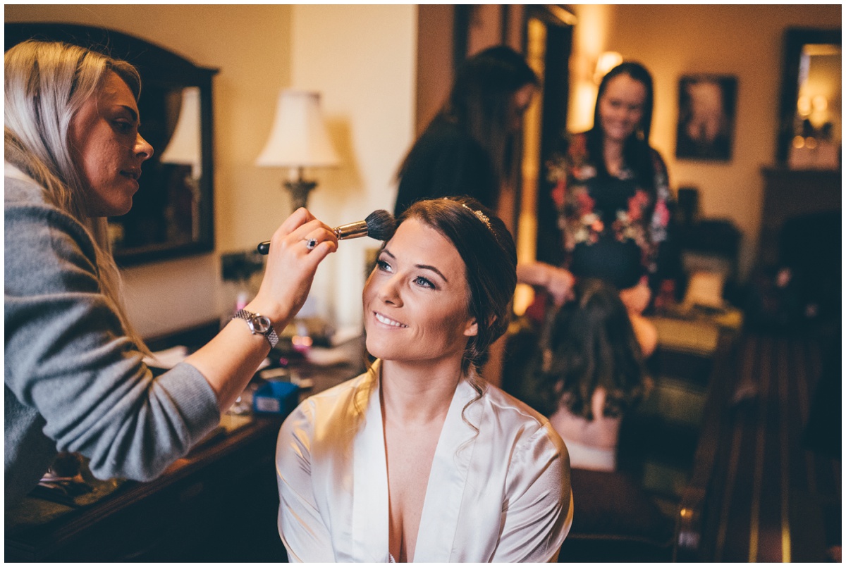 Beautiful bride has finishing touches to her wedding make up.