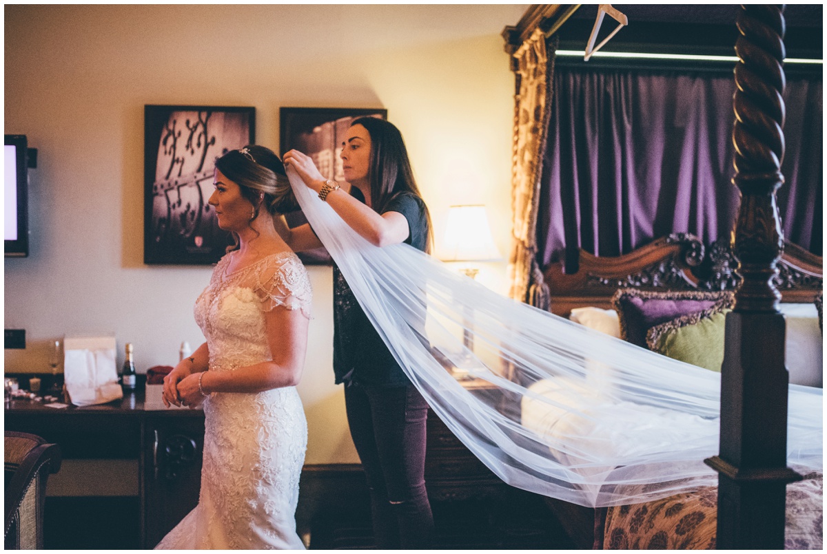 The beautiful bride has her veil put in.