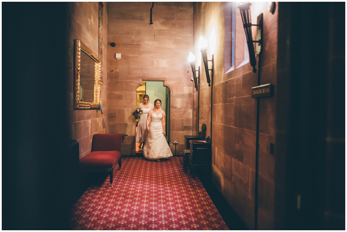 Bride leads her bridesmaids through the corridors at Peckforton Castle.