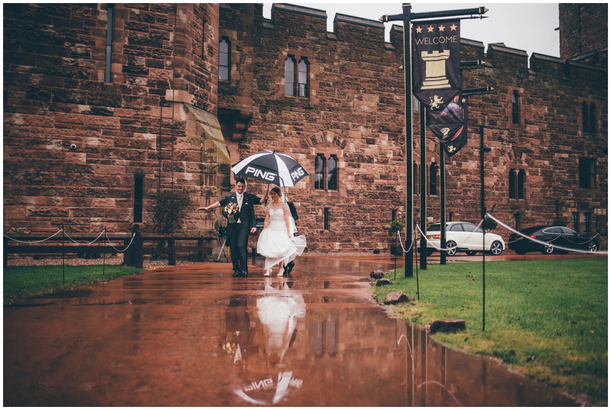 Sarah and Adam walk through the rainy grounds of Peckforton Castle.