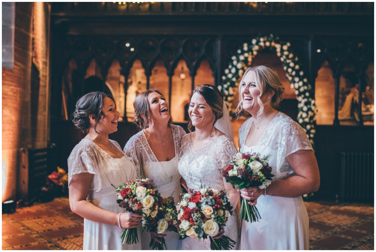 The bride laughs with her bridesmaids at Peckforton Castle.