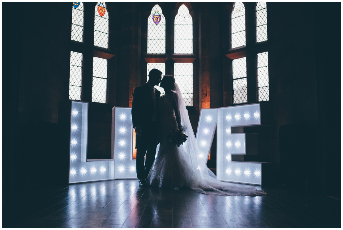 The new husband and wife have their wedding portraits taken in the Great Hall at Peckforton Castle.