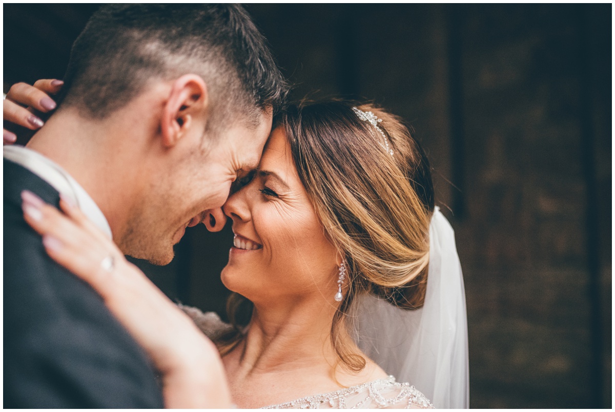 The bride and groom have their wedding photographs taken at the entrance of Peckforton Castle.