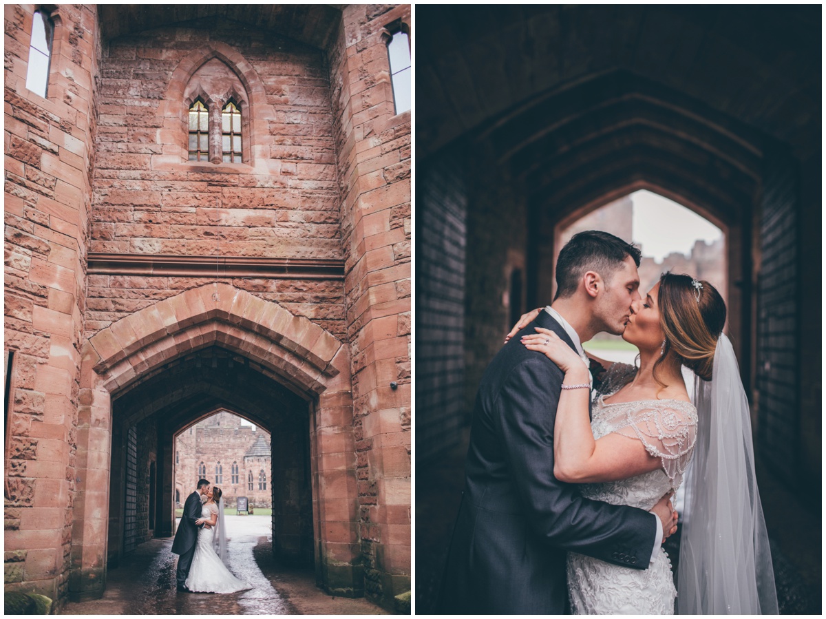 The bride and groom have their wedding photographs taken at the entrance of Peckforton Castle.