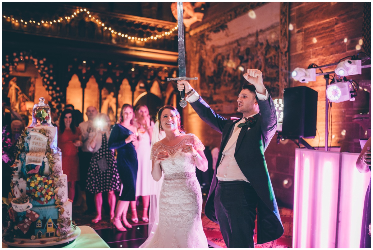 Groom celebrates cutting his amazing wedding cake at Peckforton Castle.