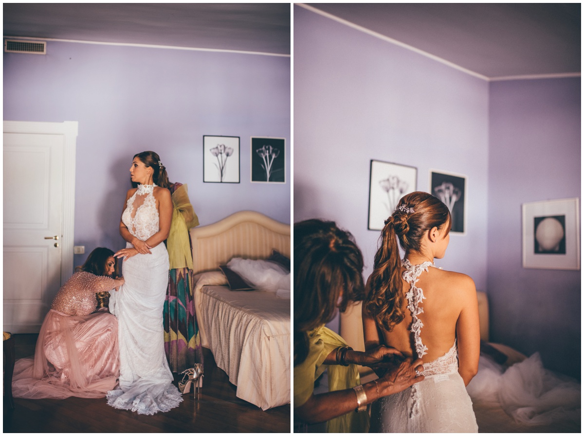 Everyone helps the bride get into her beautiful wedding gown.