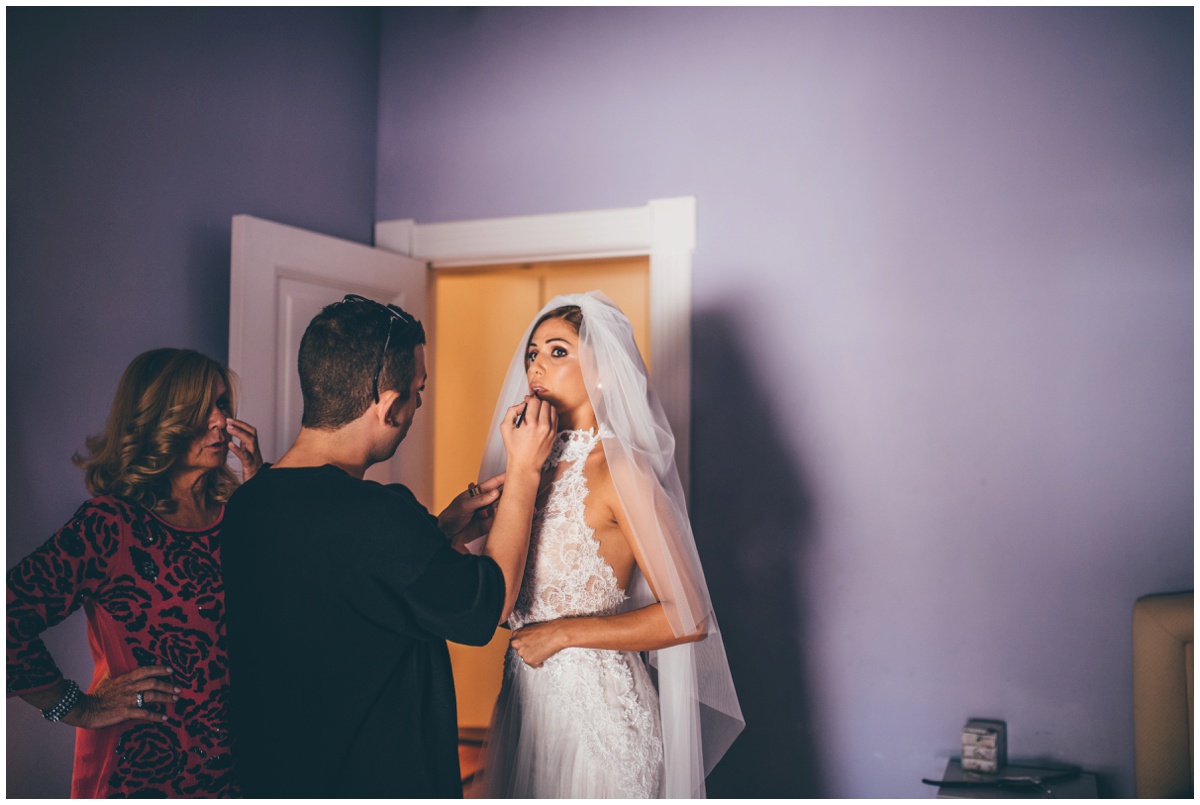 The MUA applies the last of the beautiful Italian bride's lipstick.