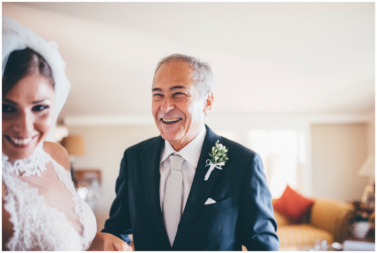 The bride's dad sees her fr the first time in her wedding dress.