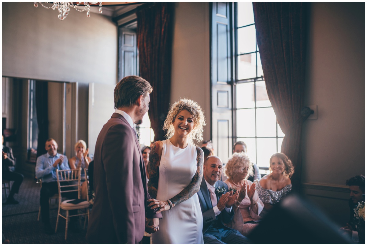 Bride and groom share a joke during their wedding ceremony in Chester.