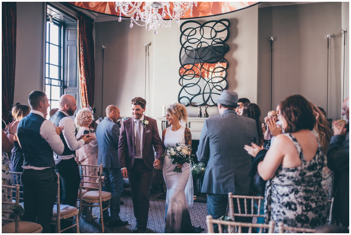 Bride and groom are applauded by their wedding guests in Chester.