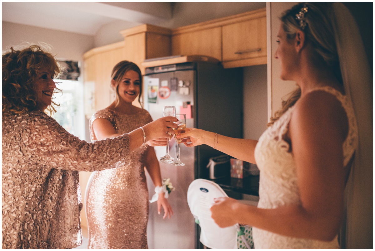 Bride and her bridesmaids cheers a champagne on the wedding morning.