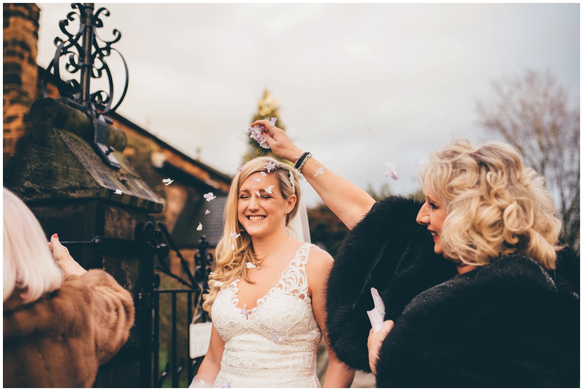 Guests pour confetti on New Years Eve bride in Cheshire.