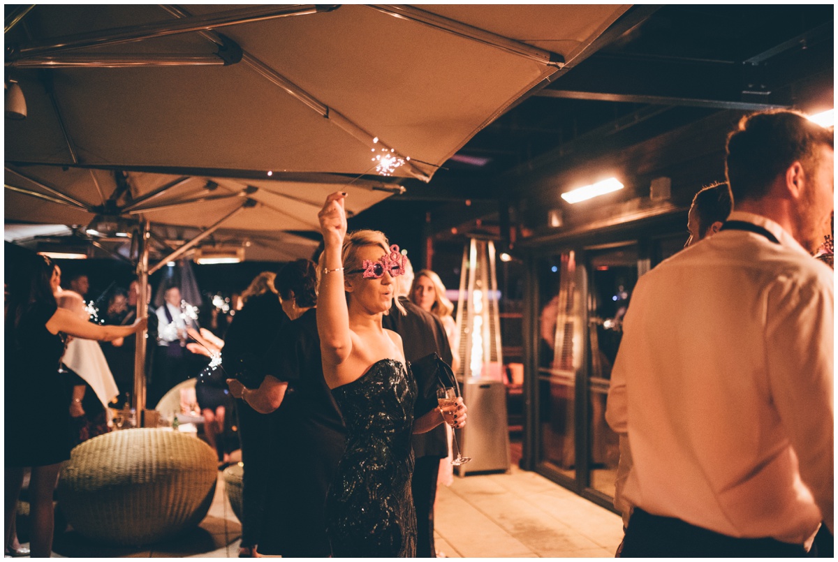Wedding guests celebrate the New Years with sparklers at New Years Eve wedding at Great John Street Hotel in Manchester.