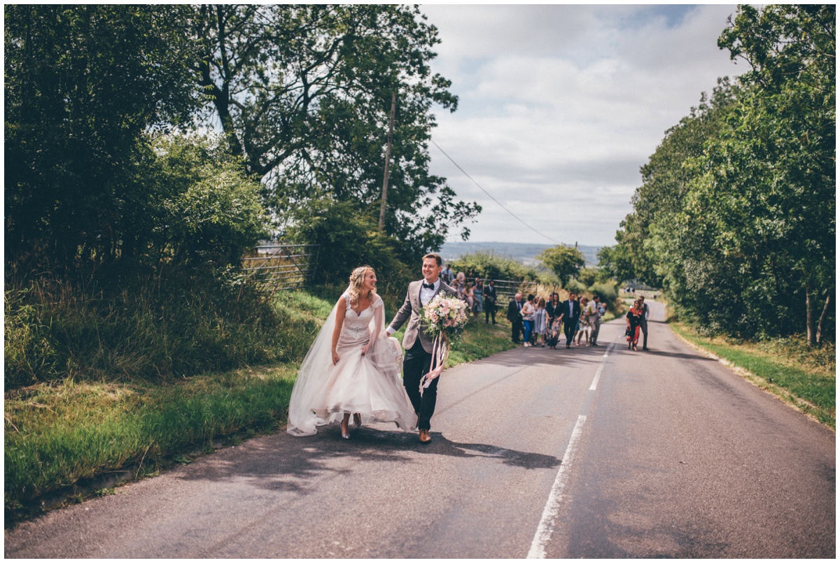 Bride and groom walk up the pretty country road, shot by Cheshire wedding photographer.