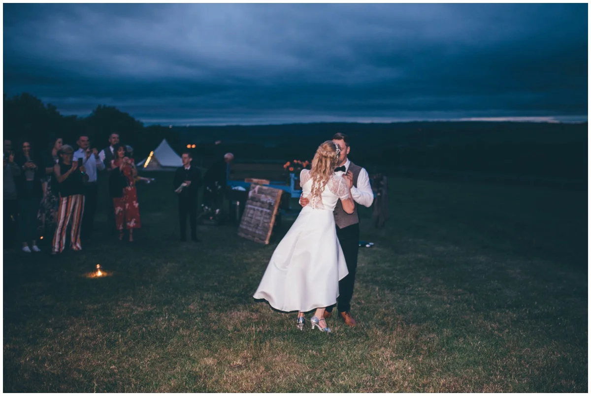 Bride and groom have their First Dance outside their wedding tipi in Staffordshire.