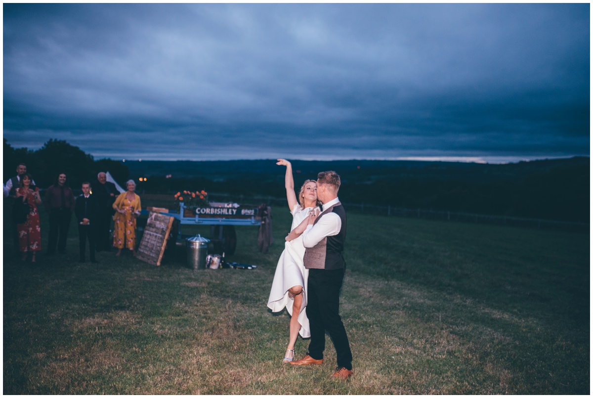 Bride and groom have their First Dance outside their wedding tipi in Staffordshire.