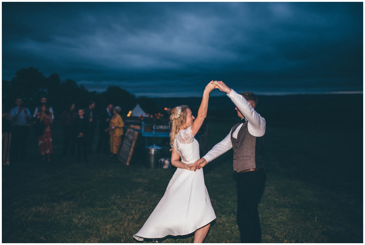 Bride and groom have their First Dance outside their wedding tipi in Staffordshire.