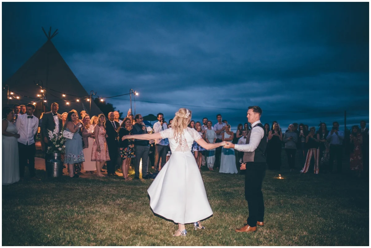 Bride and groom have their First Dance outside their wedding tipi in Staffordshire.