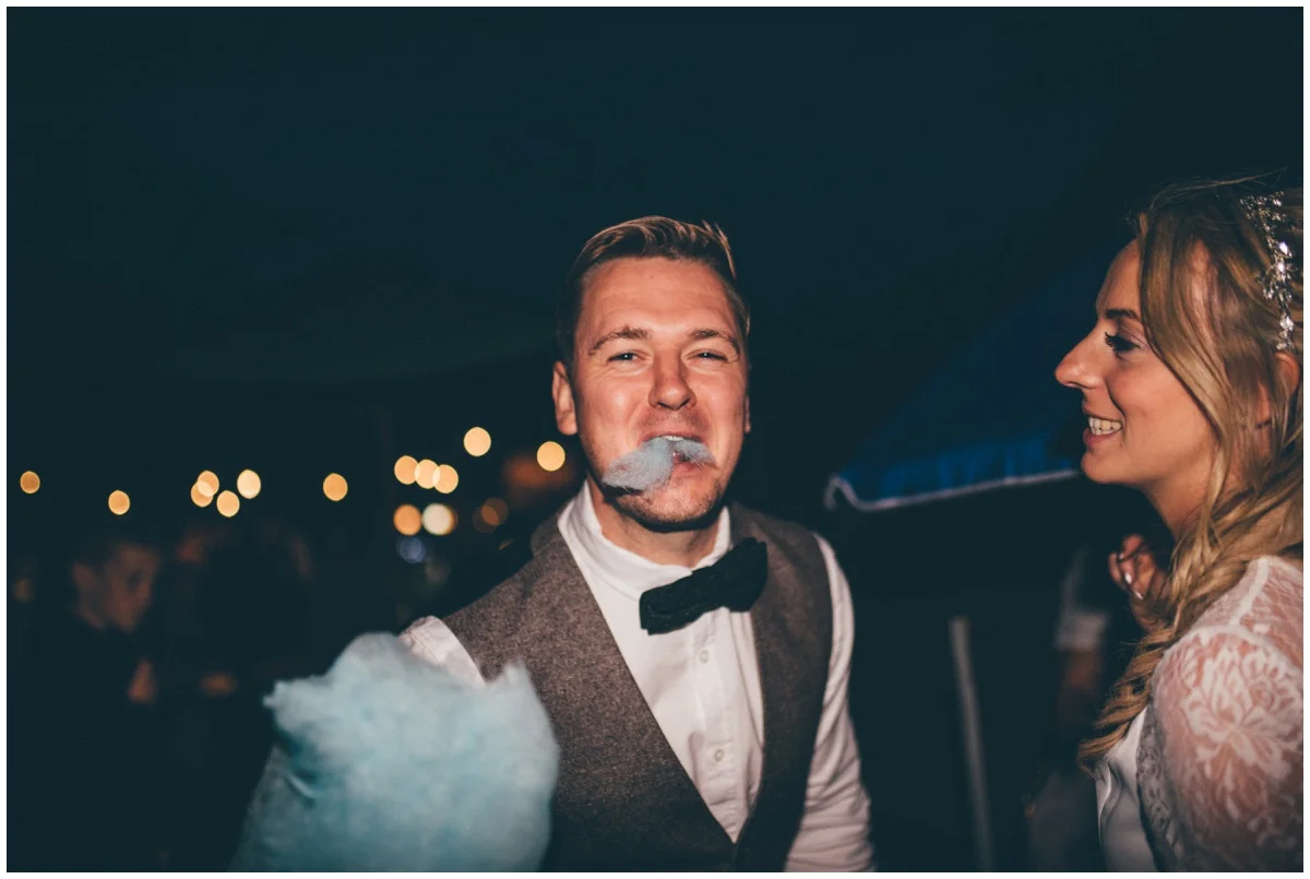 Bride and groom share candy floss at their tipi wedding in Staffordshire.
