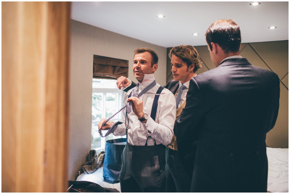 The Best Man helping the groom do his tie.