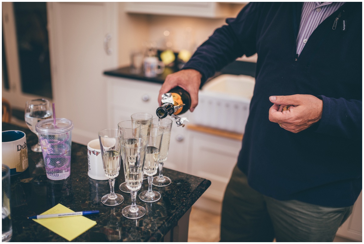 Father of the bride pours champagne for all the bridesmaids.