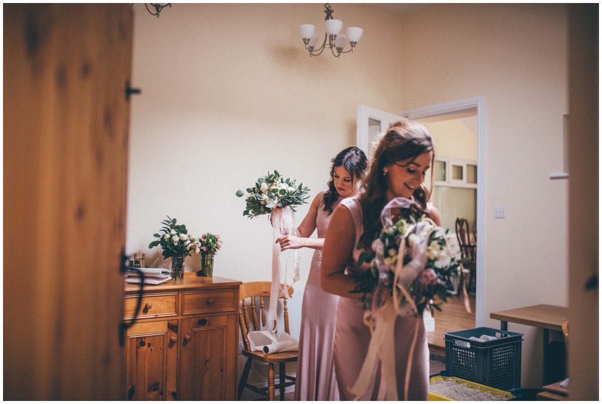 The bridesmaids in their pink dresses collect their Red Floral wedding bouquets.