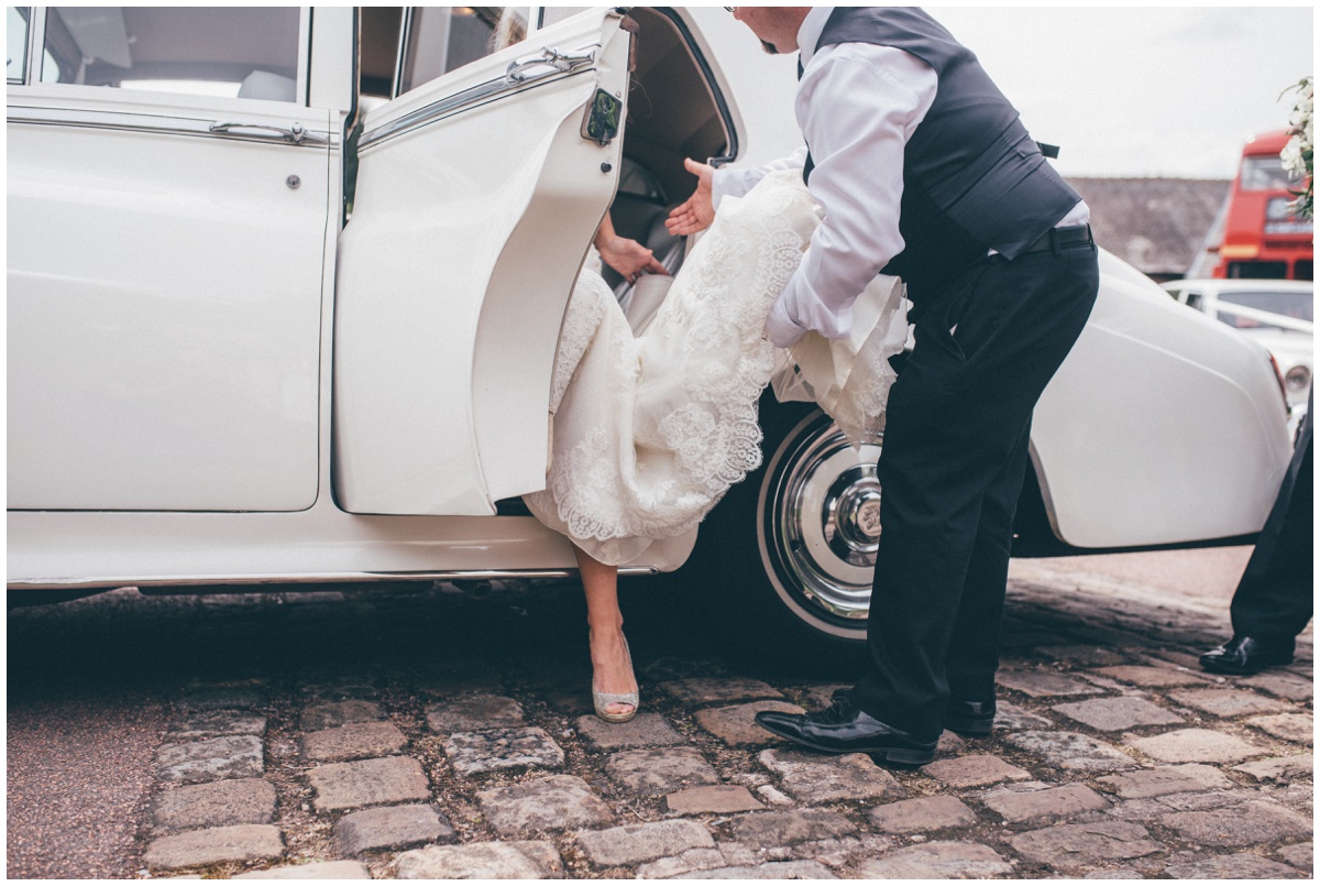 Bride steps out of her vintage wedding car in her Jimmy Choo shoes.