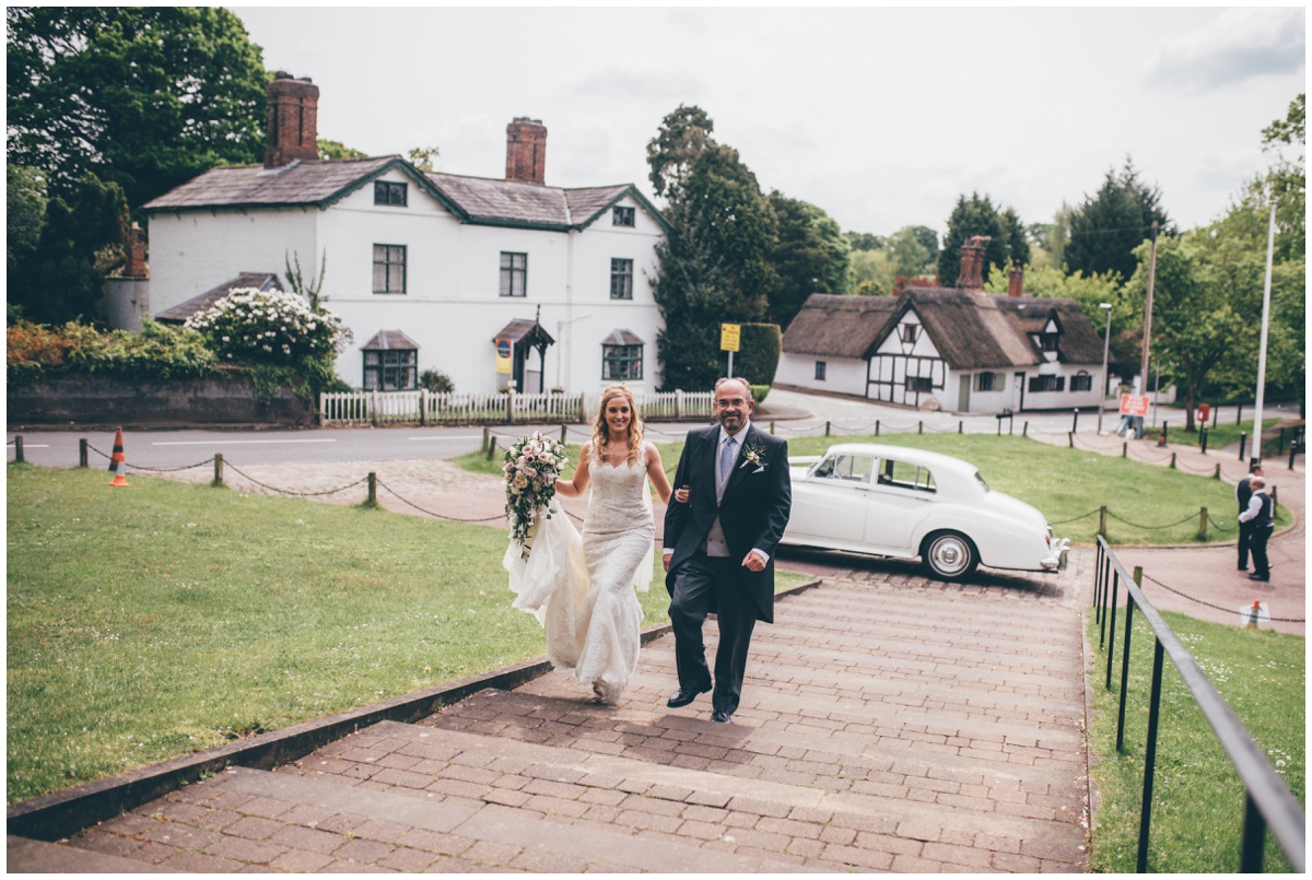 Bride walks up the steps to St Mary's Church in Cheshire with her Dad before her wedding.